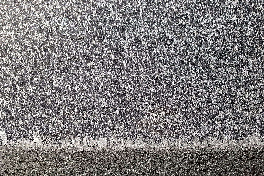 Abstract texture of salt crystals on a dark car hood