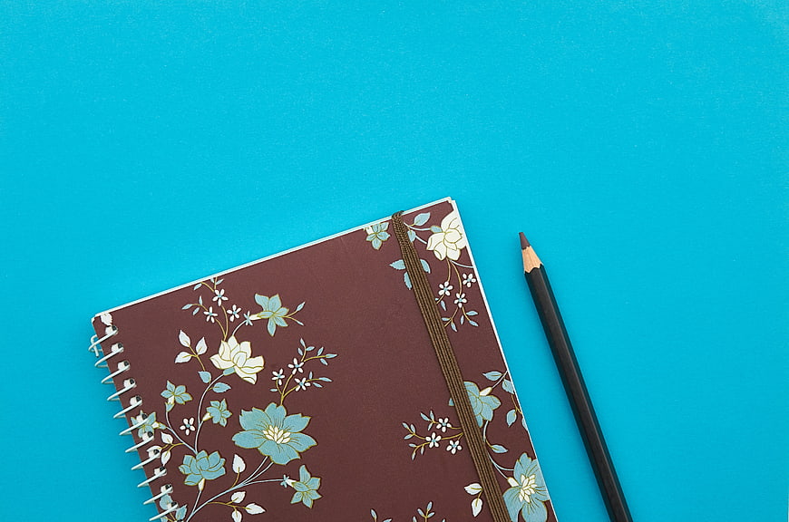 Floral Notebook and Pencil on Blue Background