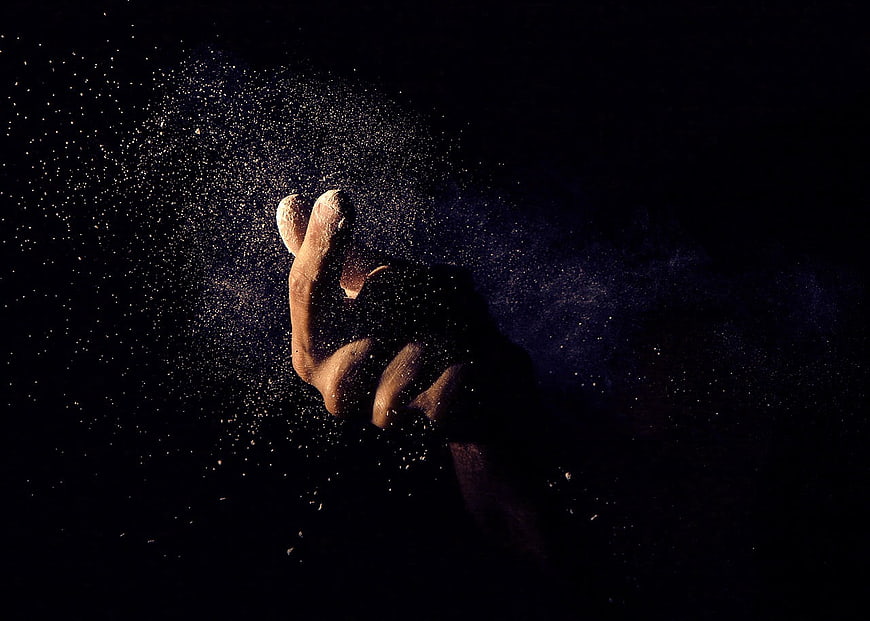 Hand Flicking Glittering Dust Particles in Dark Studio