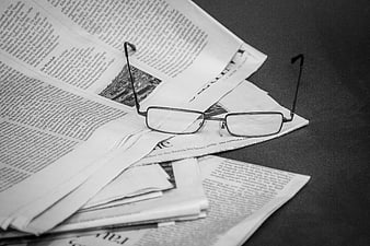 Black and white glasses on newspaper