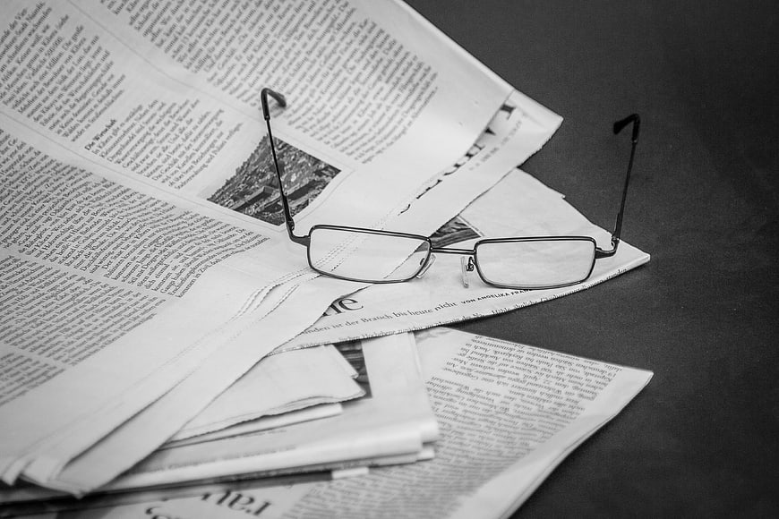 Black and white glasses on newspaper