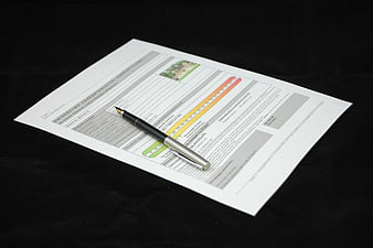 Energy efficiency certificate document with pen on black background