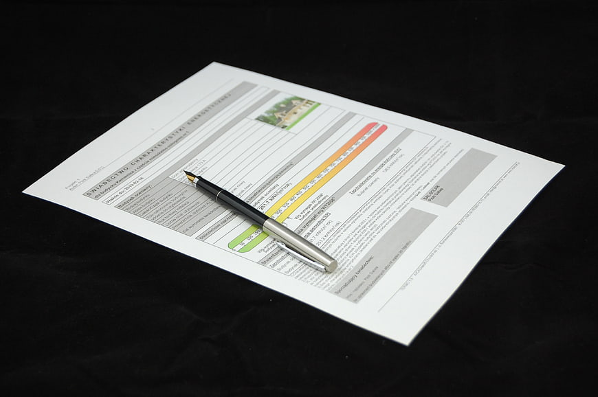 Energy efficiency certificate document with pen on black background