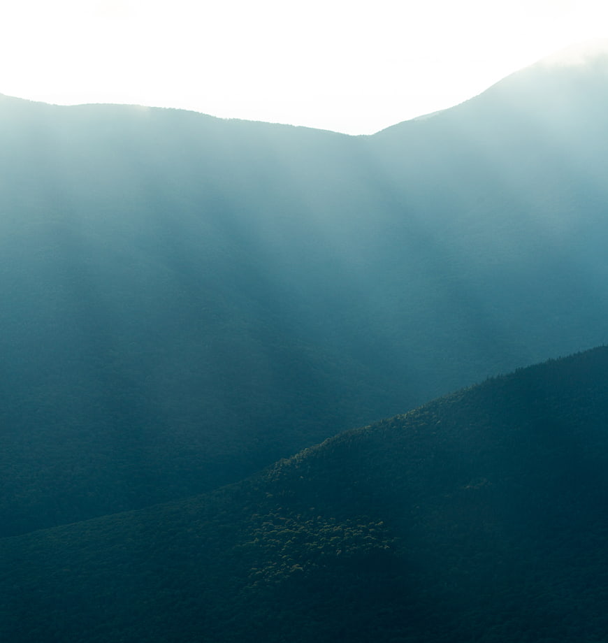 Misty Mountain Landscape with Sunbeams and Blue Haze