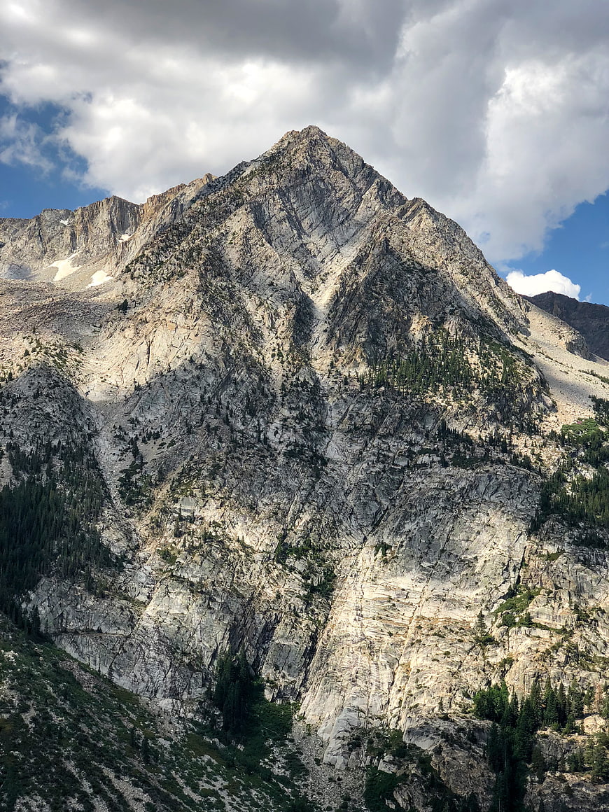 Majestic Rocky Mountain Peak with Clouds and Pine Trees