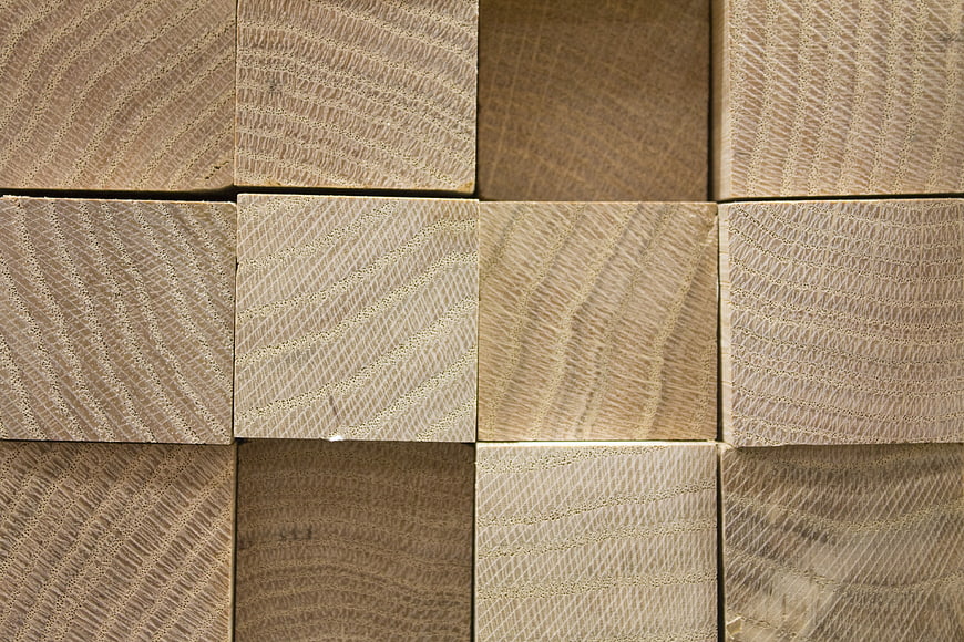 Close-up texture of stacked square timber lumber blocks