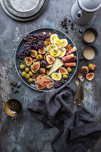Overhead view of gourmet charcuterie board with figs, cheese, and eggs