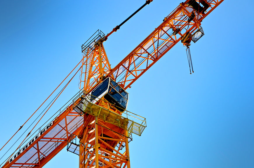 Orange Tower Crane Against Blue Sky