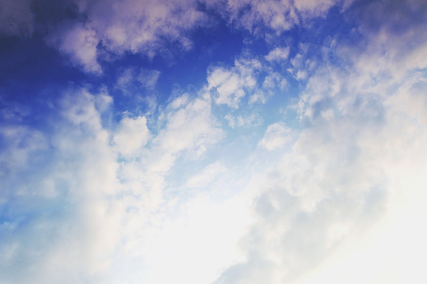 Bright blue sky with fluffy white clouds and sunlight
