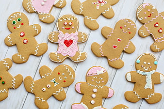 Decorated Gingerbread Man Cookies With Pink Icing On White Wood