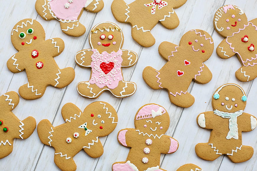 Decorated Gingerbread Man Cookies With Pink Icing On White Wood