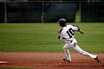 Baseball Player Running on Dirt Field