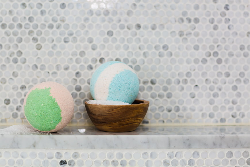 Pastel Bath Bombs on Marble Shelf with Wooden Bowl