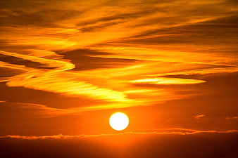 Vibrant Orange Sunset with Streaky Clouds and Bright Sun