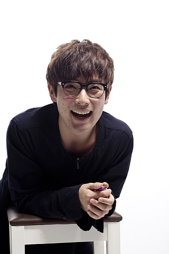 Happy Asian Man with Glasses Leaning on Stool