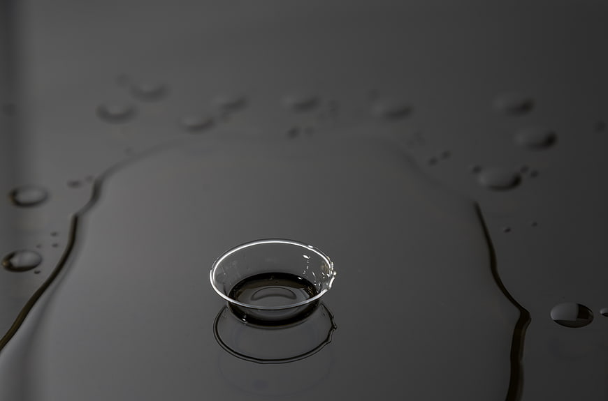 Close-up of water droplets on a dark reflective surface