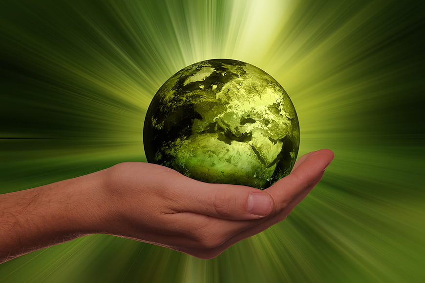 Hand holding green glowing globe for sustainability