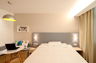 Modern Hotel Room Interior with Bed and Laptop