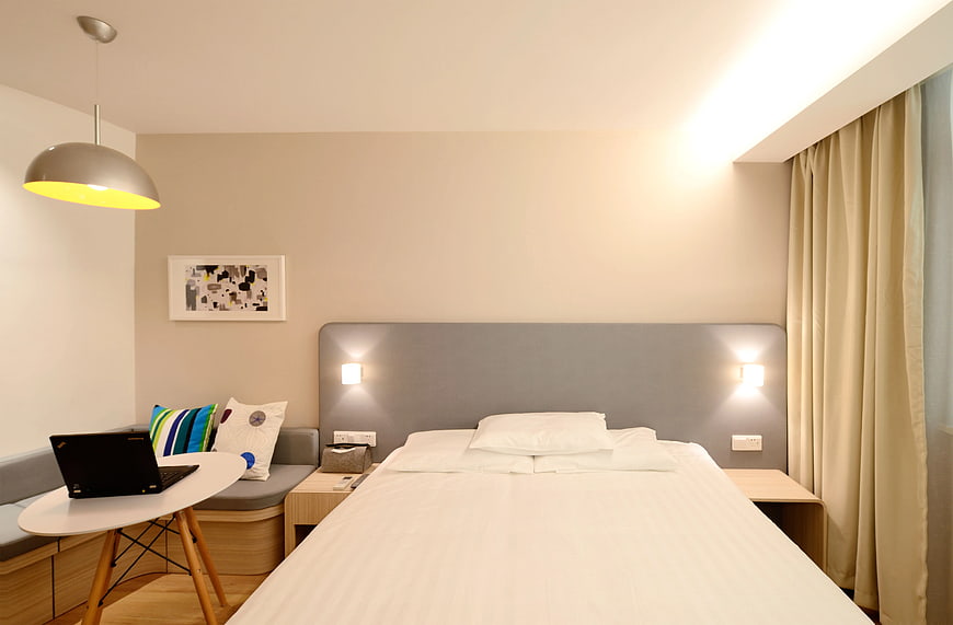 Modern Hotel Room Interior with Bed and Laptop