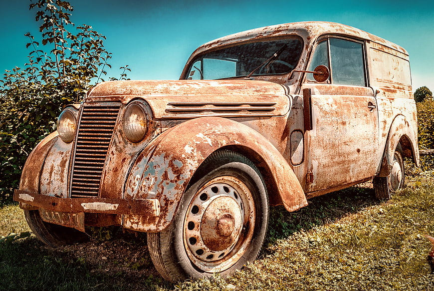 Rusty vintage Renault Juvaquatre van in field