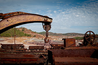Rusty Mining Crane and Train Cars in Abandoned Quarry