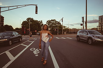 Stylish Woman Walking in City Street at Sunset