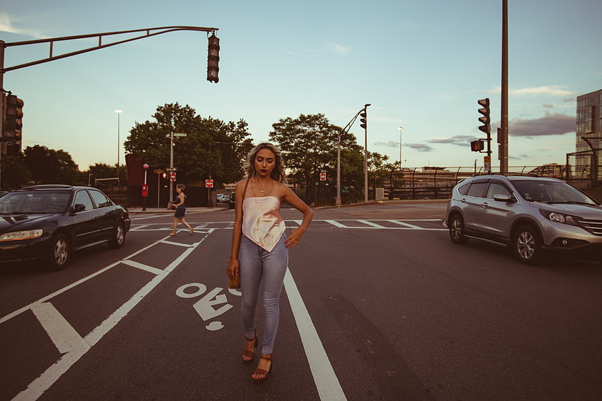 Stylish Woman Walking in City Street at Sunset