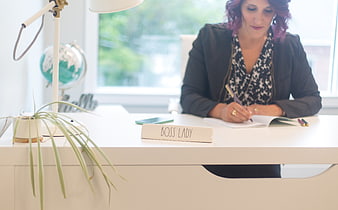 Woman with Boss Lady Nameplate Writing at Office Desk