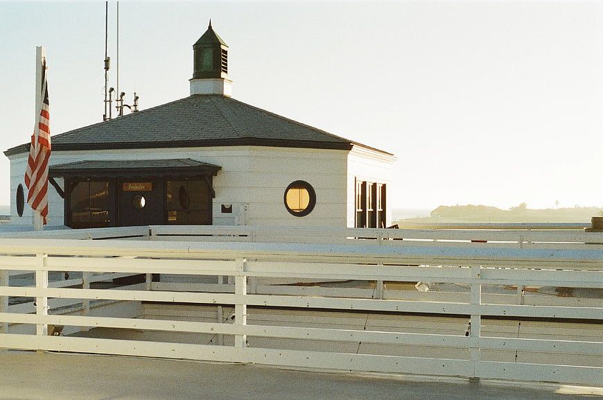 White Lighthouse Building with American Flag and Wooden Fence