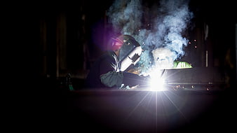 Industrial Welder Working with Sparks and Smoke