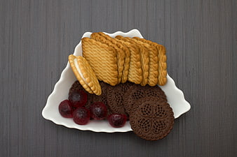 Assorted cookies and dried cranberries on a white plate