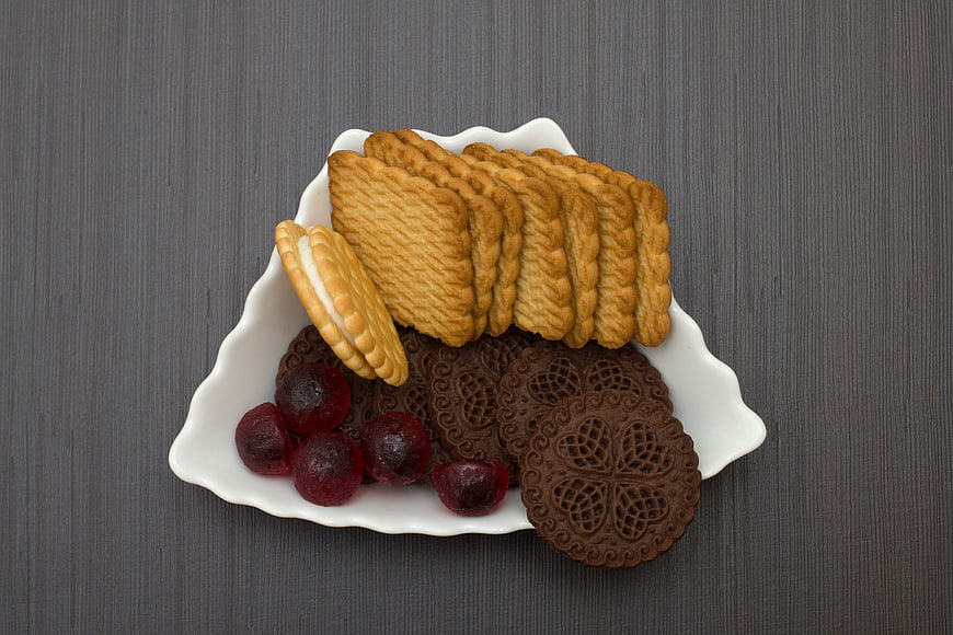 Assorted cookies and dried cranberries on a white plate