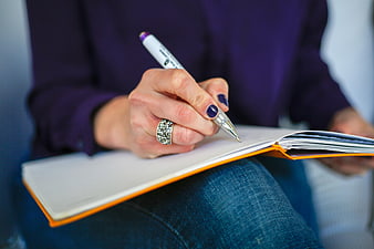 Woman Writing in Notebook with Pen