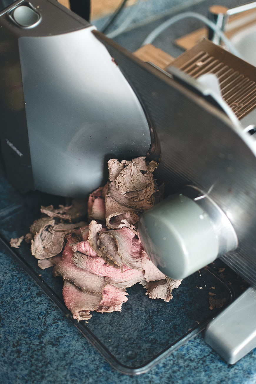 Sliced roast beef on electric meat slicer