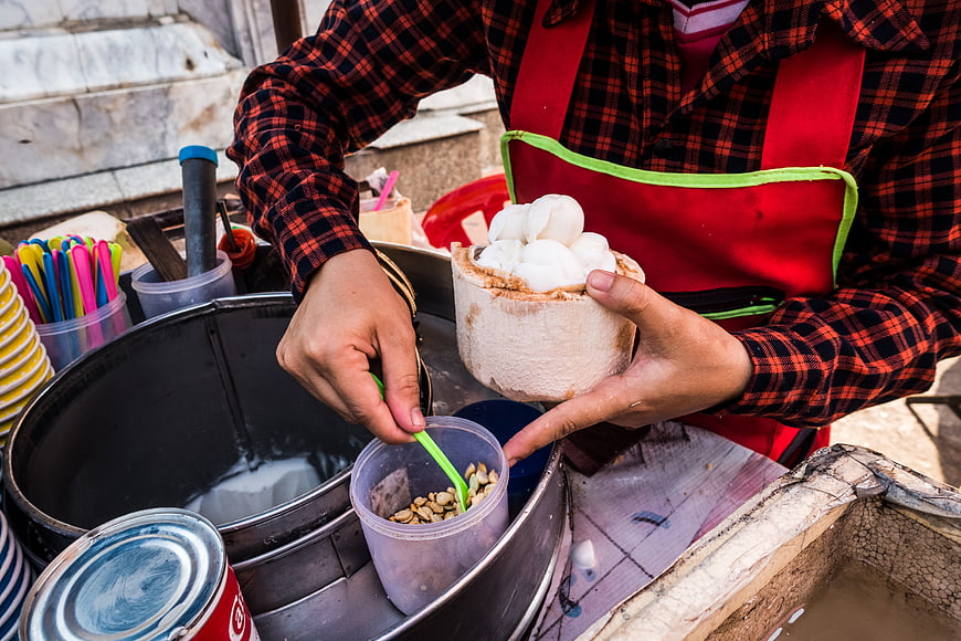 Street vendor serving fresh coconut ice cream dessert