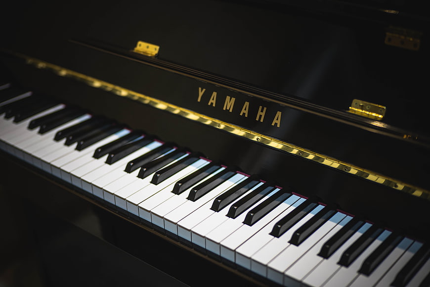 Close-up of Yamaha Grand Piano Keys and Gold Logo