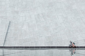 Minimalist Aerial View of Couple Sitting on Modern Concrete Plaza