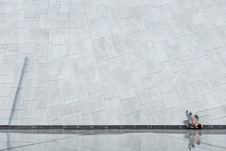 Minimalist Aerial View of Couple Sitting on Modern Concrete Plaza