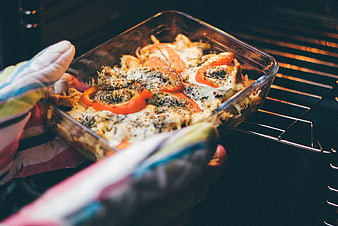 Homemade Casserole Being Removed from Oven with Oven Mitts
