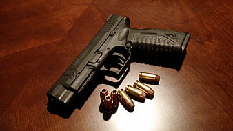 Black Pistol And Brass Bullets On Wooden Table