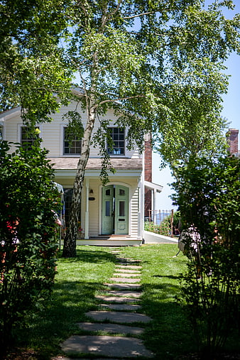 Charming White House with Green Door and Stone Pathway