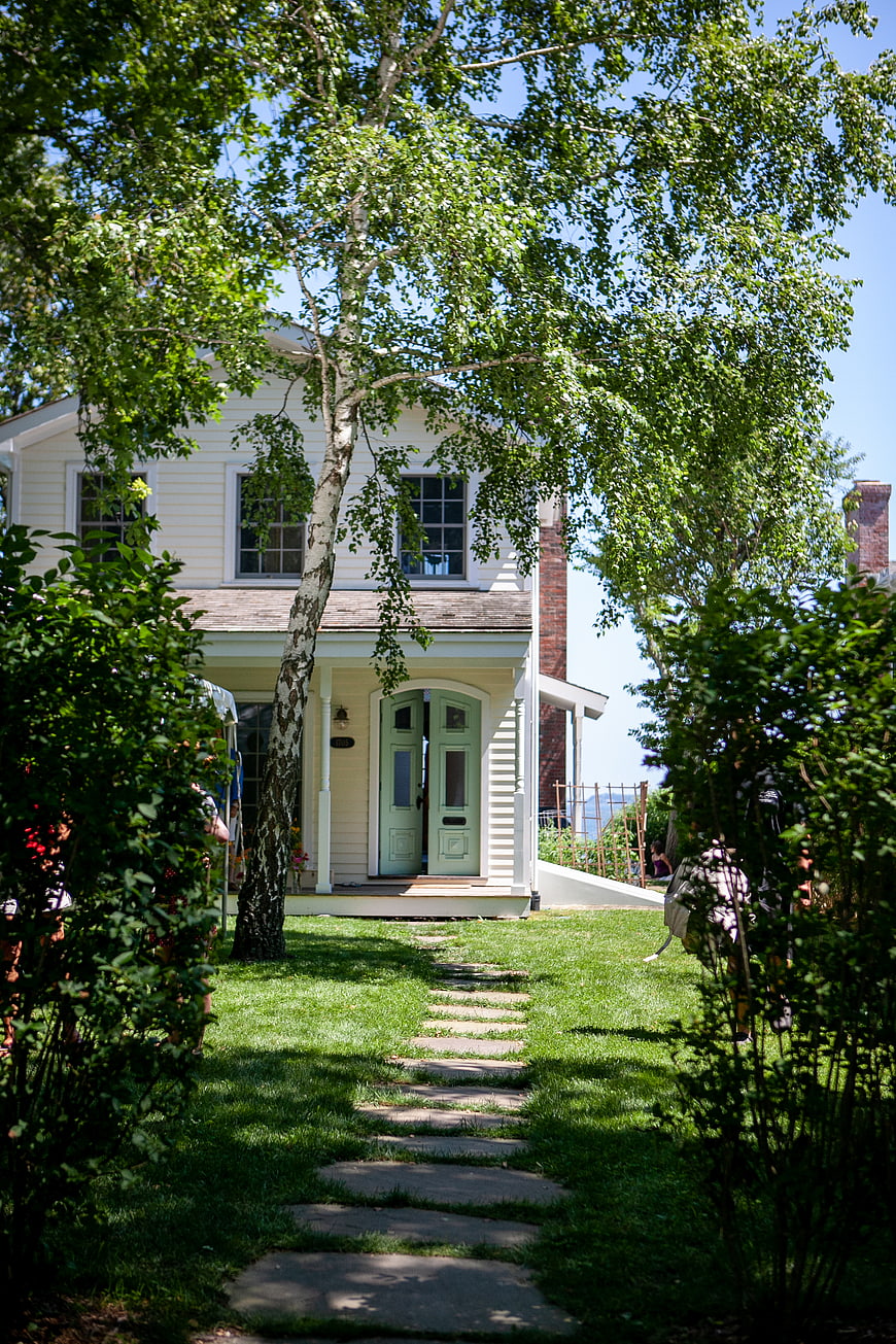 Charming White House with Green Door and Stone Pathway