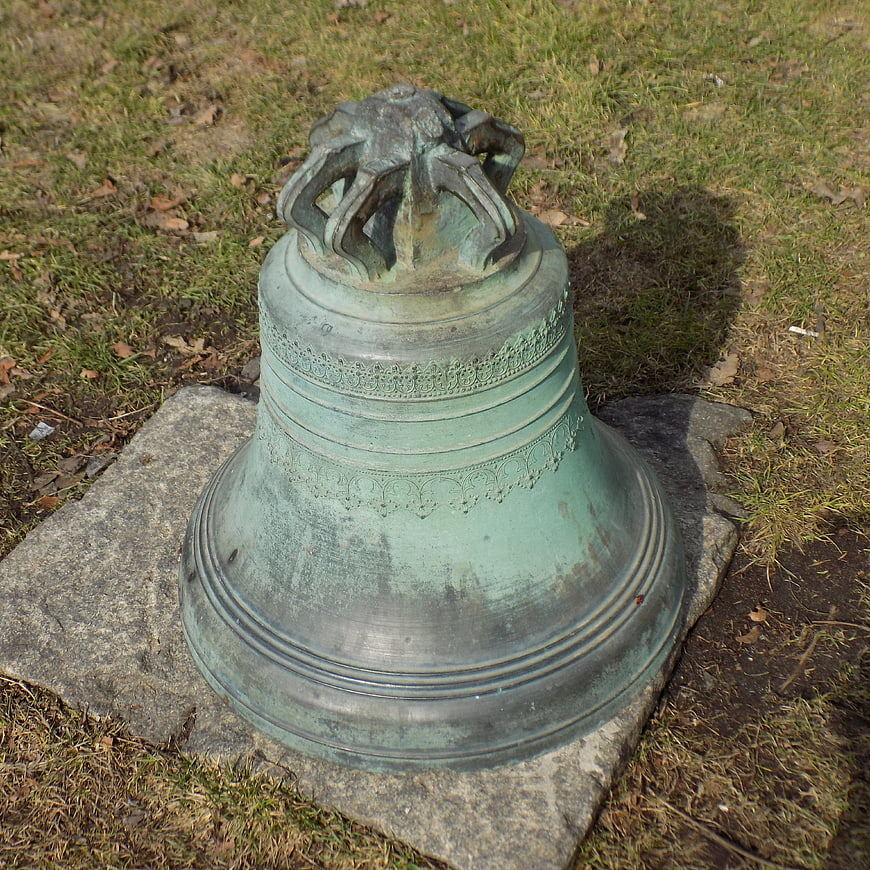 Old Bronze Church Bell on Stone Base in Grass