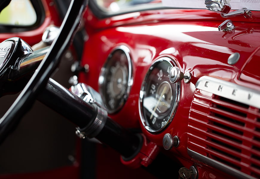 Close-up of red vintage Chevrolet dashboard and steering wheel