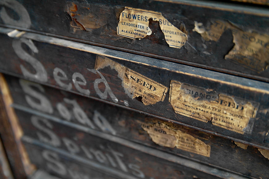 Vintage wooden seed boxes with peeling labels and handwritten text