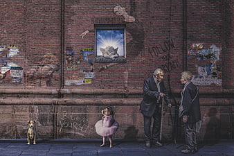 Elderly couple and young ballerina on urban street with dog