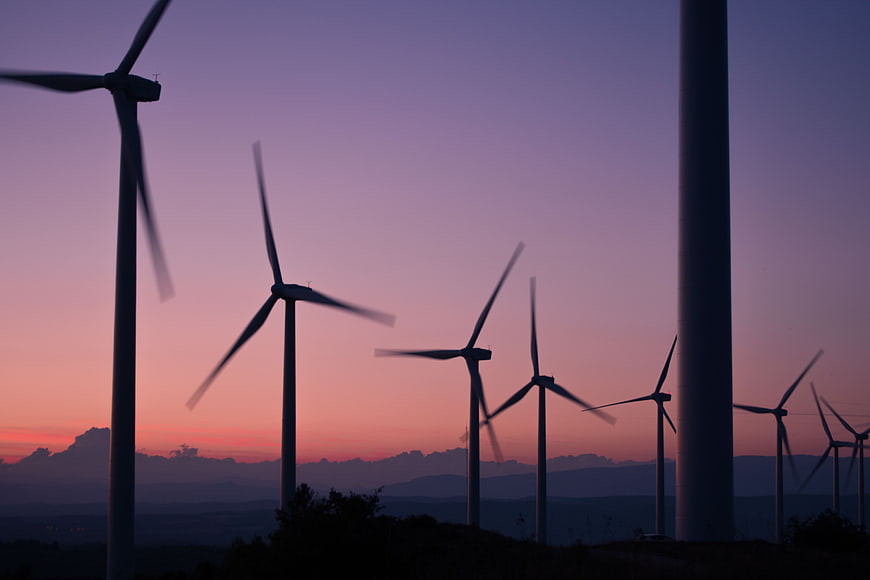 Wind Turbines Silhouette Against Purple Sunset Sky