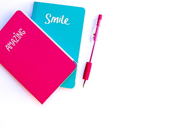 Pink and Blue Notebooks with Pen on White Background
