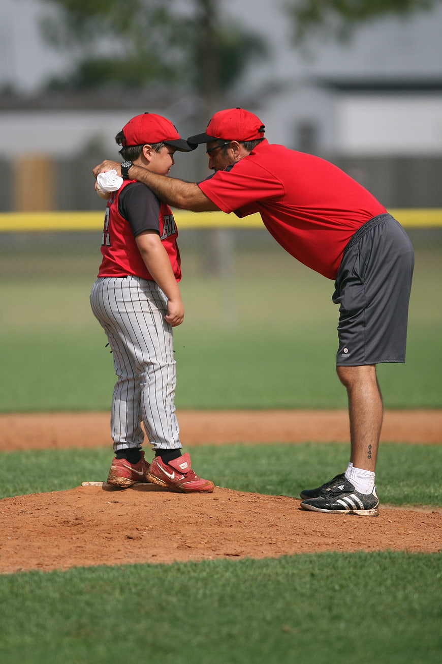 Baseball Coach Talking to Young Pitcher on Mound