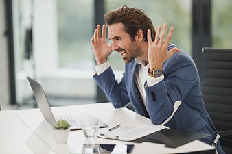 Frustrated businessman shouting at laptop in office